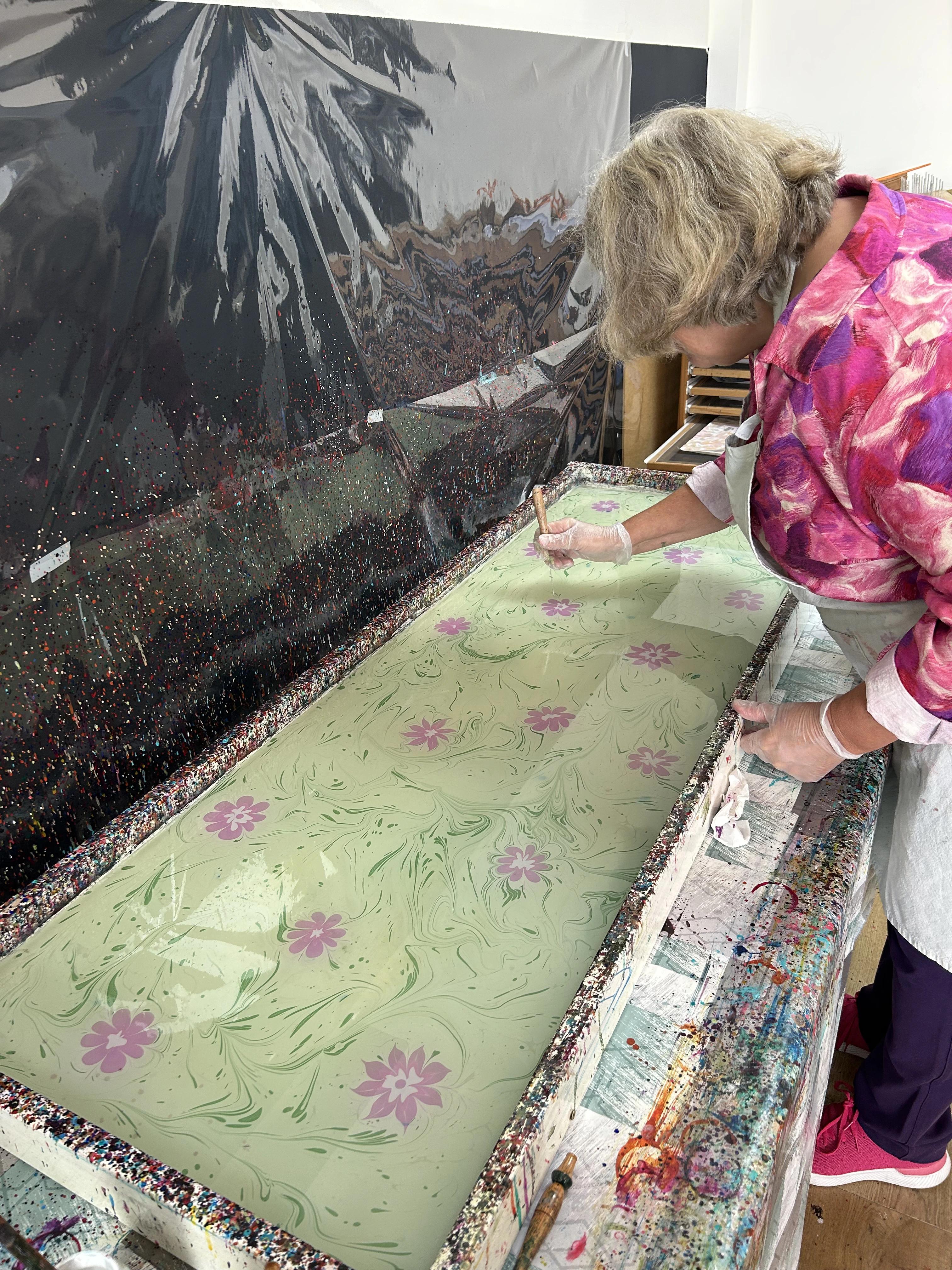 Een vrouw die geconcentreerd bezig is met ebru kunst