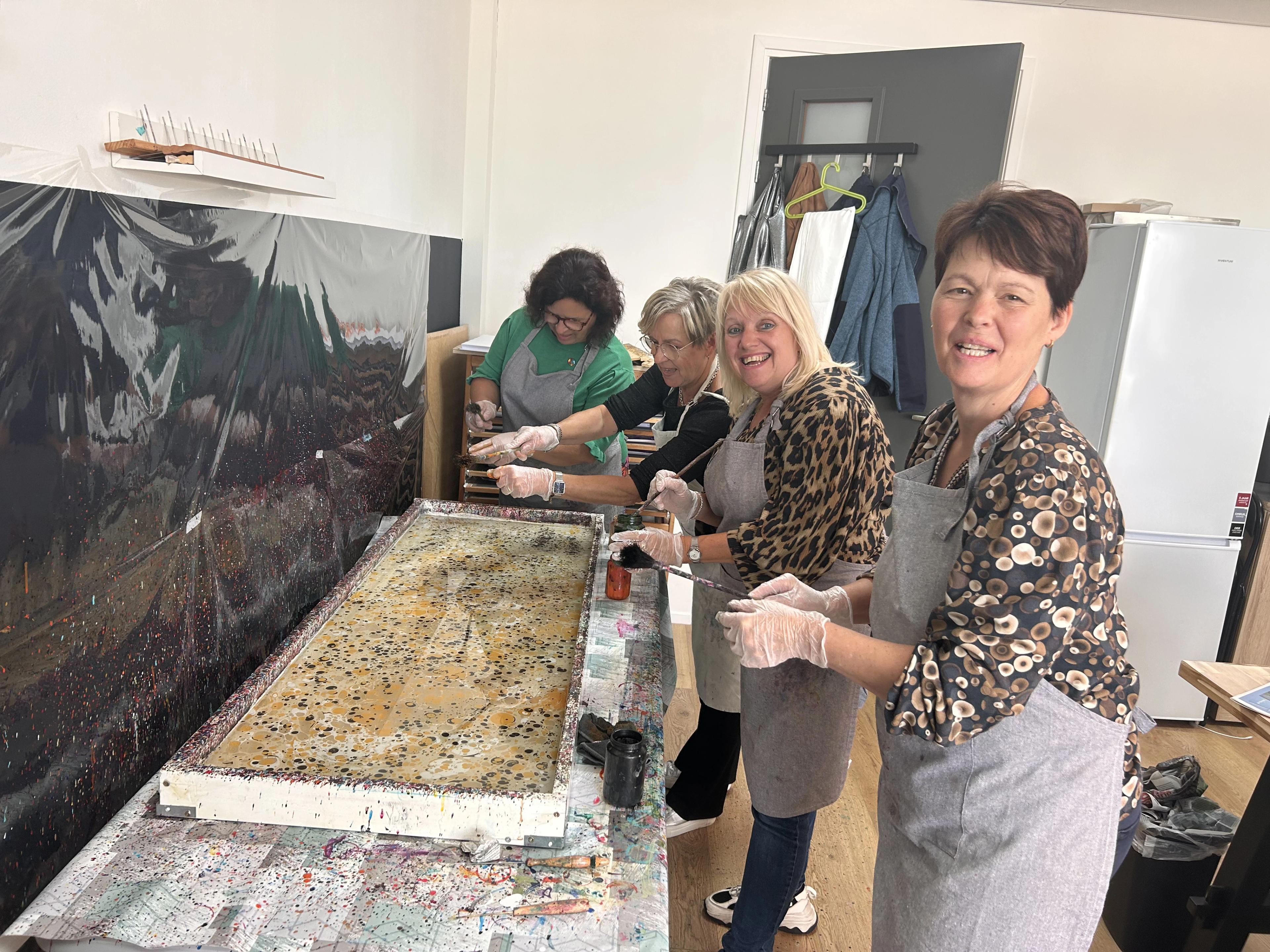 Een vrouw die geconcentreerd bezig is met ebru kunst