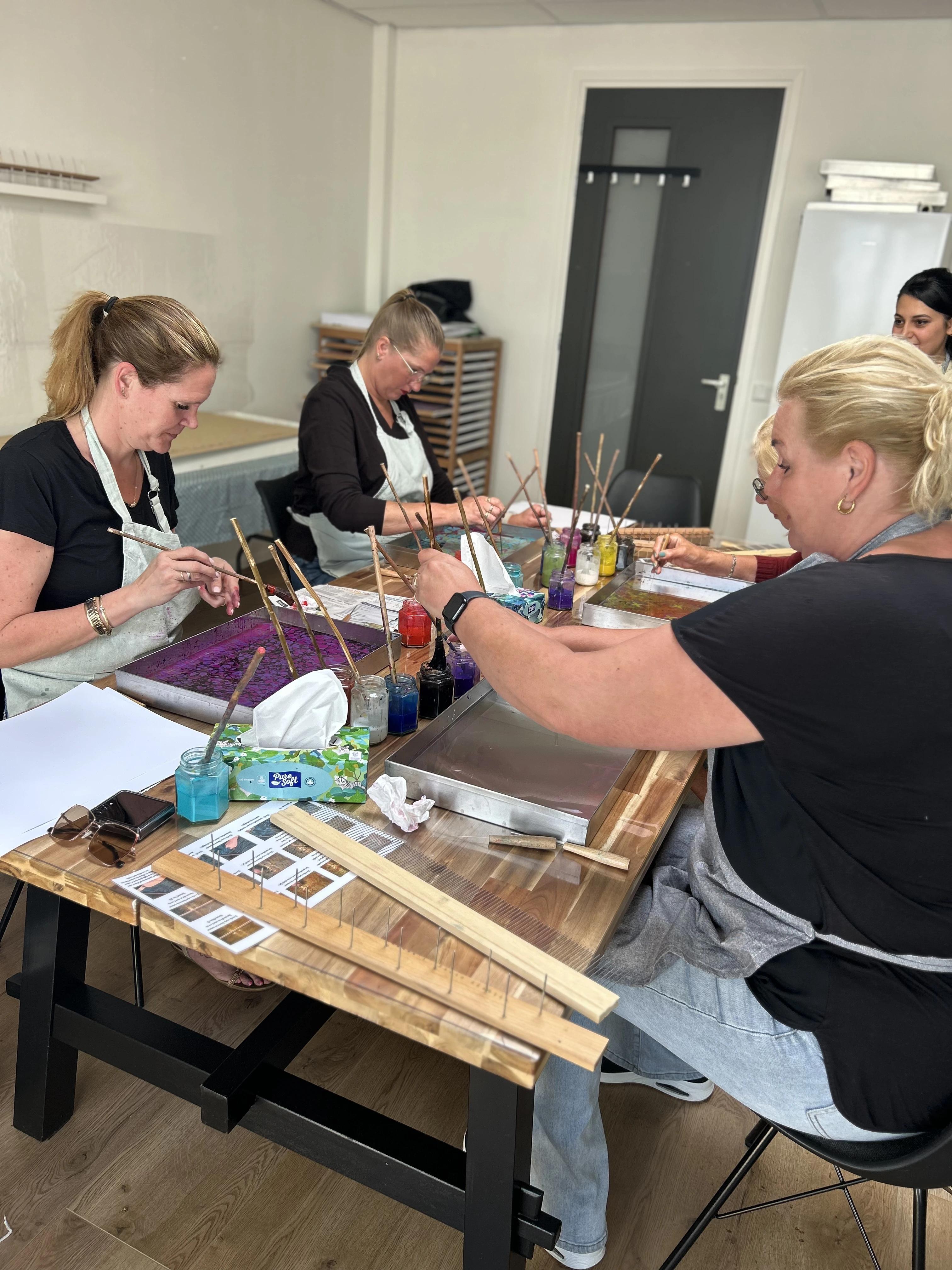 Een vrouw die geconcentreerd bezig is met ebru kunst