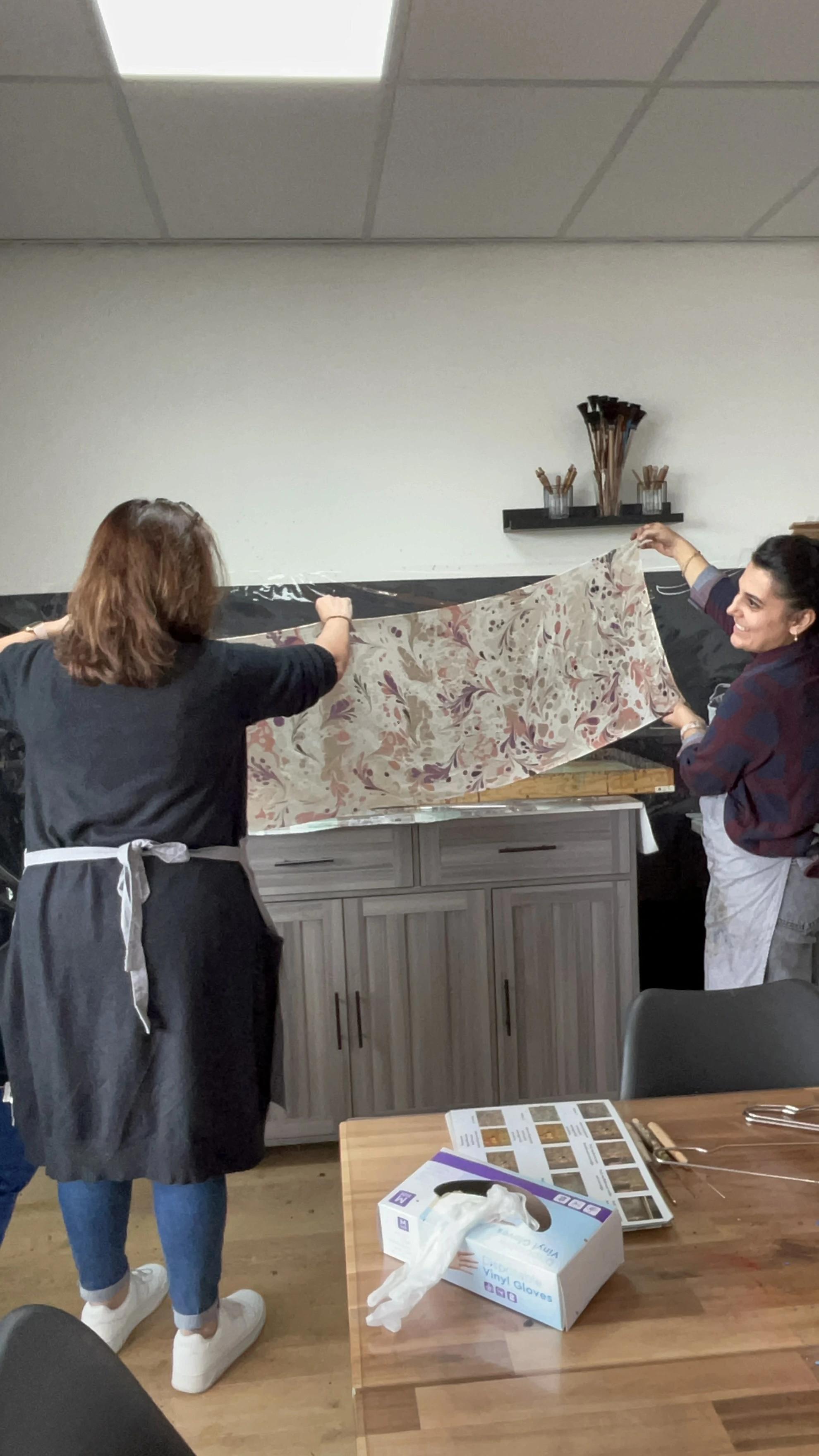 Een vrouw die geconcentreerd bezig is met ebru kunst